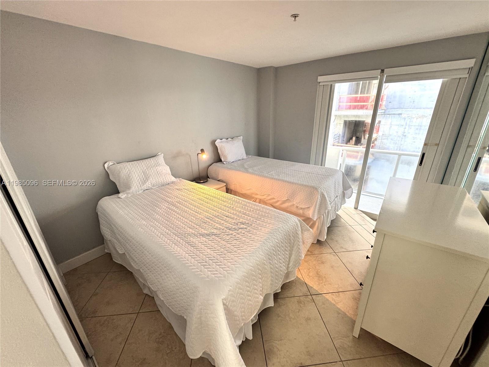 9195 Collins Avenue, Unit PH4 Surfside, FL 33154 - Photo 10 of 22 a bedroom with a bed and glass door