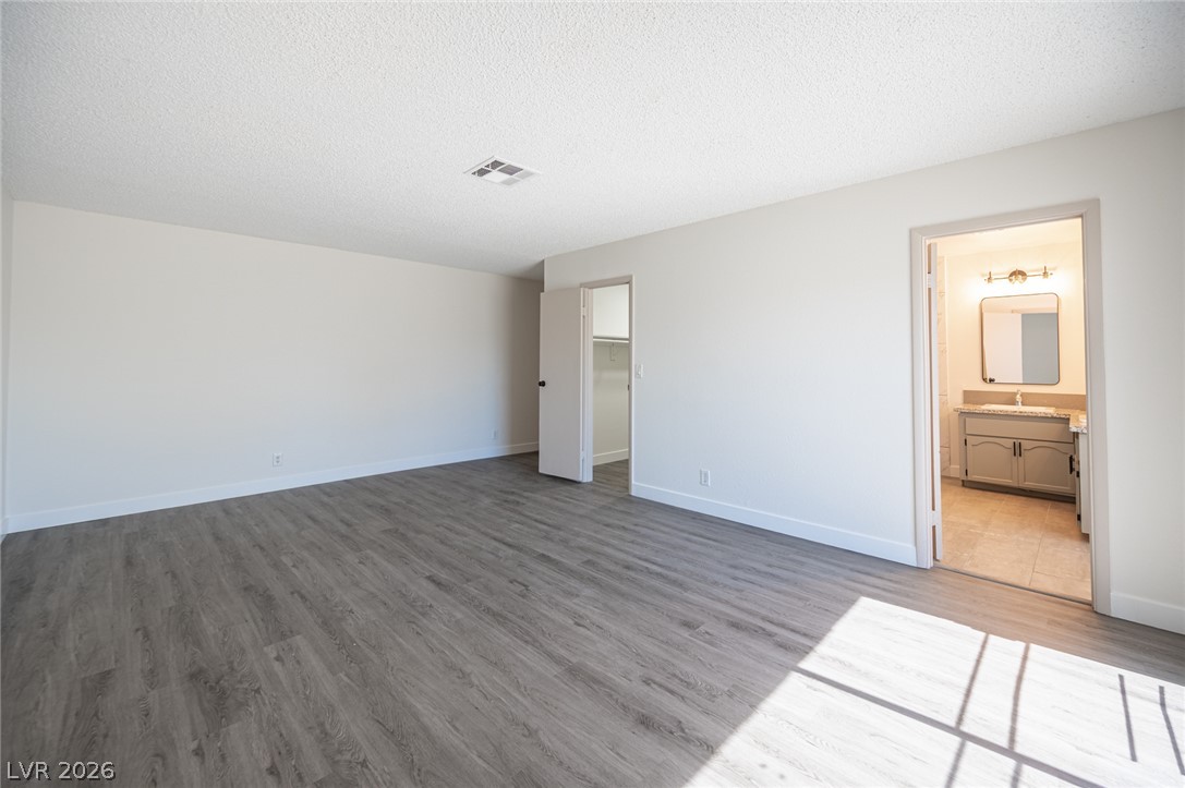 7041 North Decatur Boulevard Las Vegas, NV 89131 - Photo 17 of 33 A spacious, naturally illuminated room boasts wide plank flooring and convenient access to a private closet and bath.