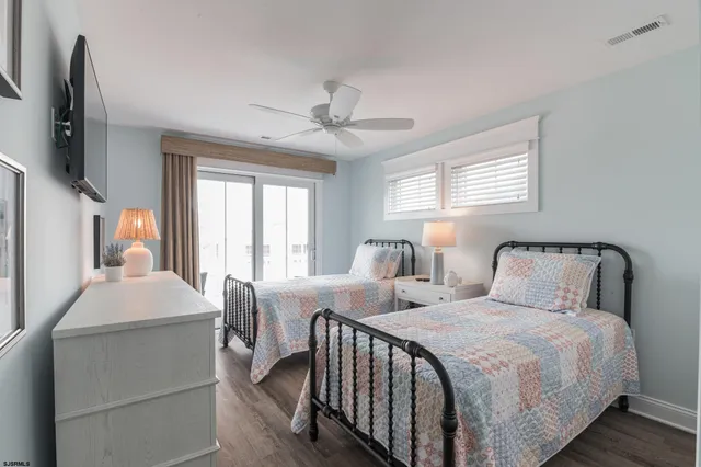a bedroom with two beds and wooden floor