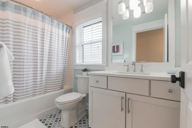 a bedroom with a bed and a flat tv screen on dresser