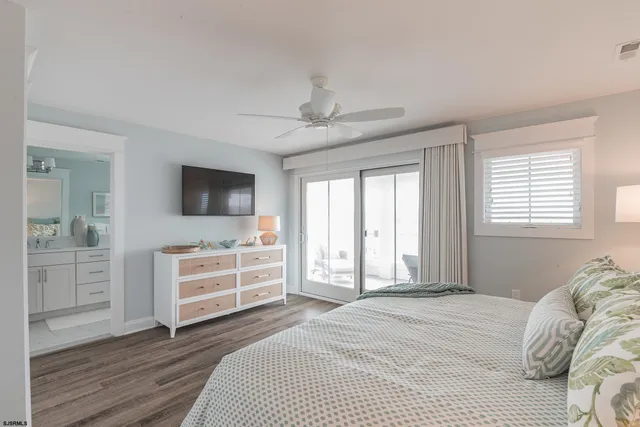 a bathroom with double sink a toilet a shower and a window