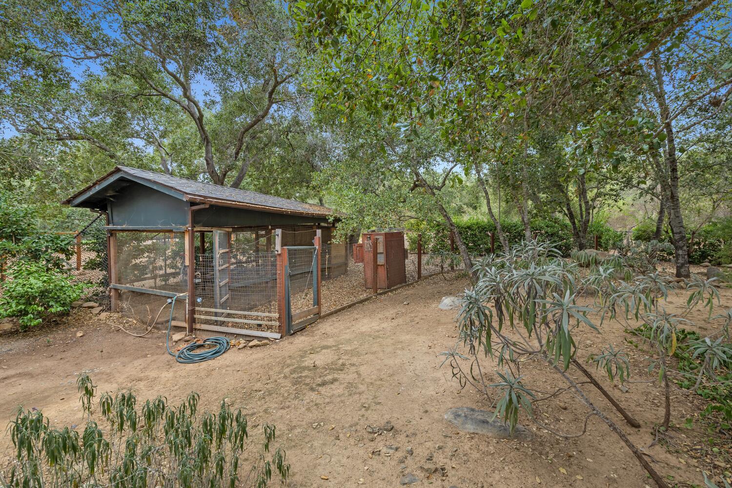 828 Foothill Lane Ojai, CA 93023 - Photo 33 of 40 a view of a barn with wooden fence and large trees