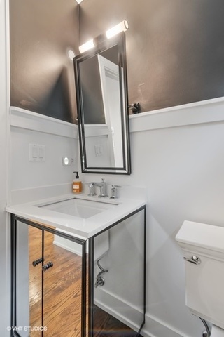 2708 West Nelson Street Chicago, IL 60618 - Photo 8 of 26 a bathroom with a sink a mirror and a toilet