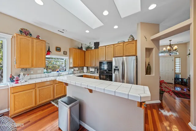 a view of a hallway with wooden floor and a living room