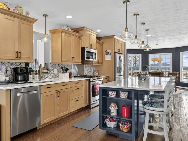 a kitchen with stainless steel appliances granite countertop a sink a stove and a wooden floors