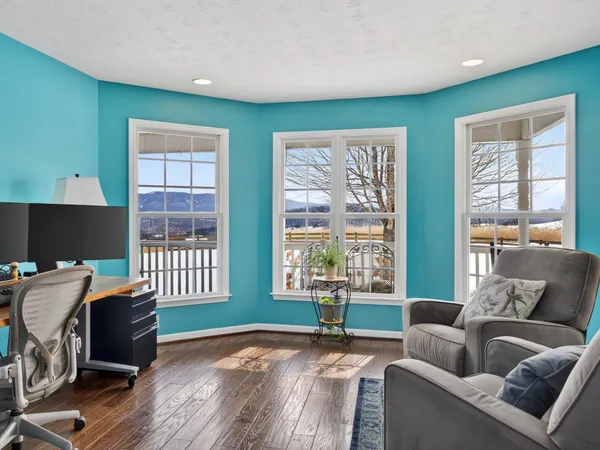a living room with furniture a flat screen tv and a window
