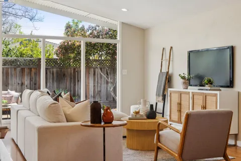 a living room with furniture a lamp and a large window