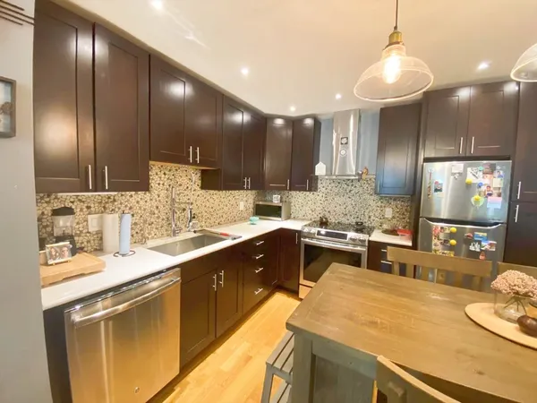 a large kitchen with stainless steel appliances kitchen island granite countertop a sink and cabinets
