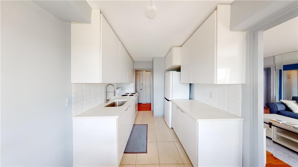 191 73rd Street, Unit 296 Brooklyn, NY 11209 - Photo 5 of 20 a kitchen with stainless steel appliances a sink and a refrigerator