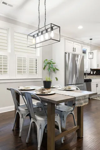 a kitchen with kitchen island white cabinets a refrigerator a stove a microwave and wooden floors