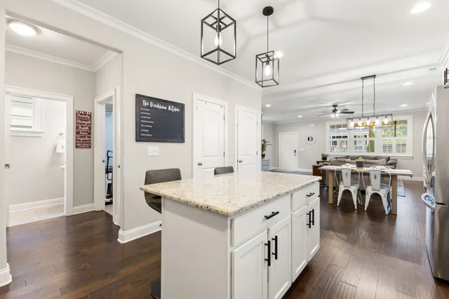 a kitchen with stainless steel appliances a refrigerator a stove and white cabinets
