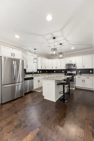 a kitchen with stainless steel appliances granite countertop a stove a sink and a microwave