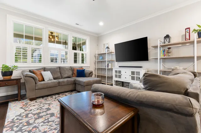 a view of a dining room and livingroom with furniture wooden floor a chandelier