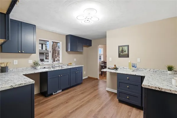 a kitchen with granite countertop a sink cabinets and wooden floor