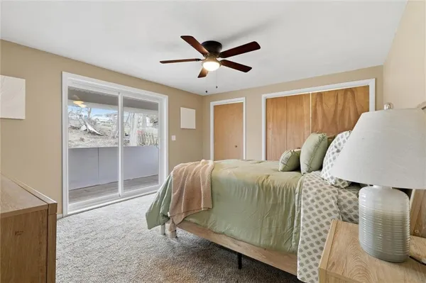a spacious bedroom with a bed and a ceiling fan