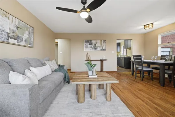 a living room with furniture a wooden floor and a dining table