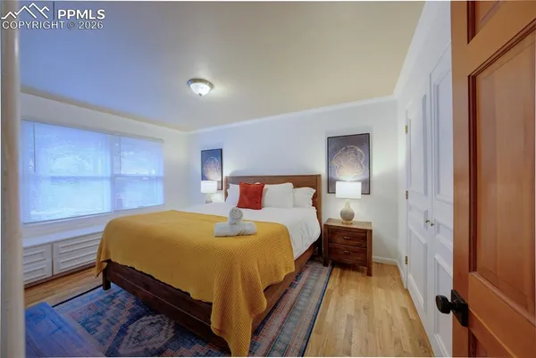 a bedroom with a bed and wooden floor