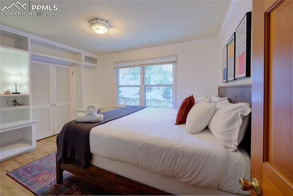 a bedroom with a bed and wooden floor
