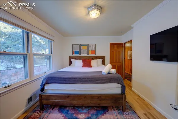 a bedroom with a bed and a flat tv screen on dresser