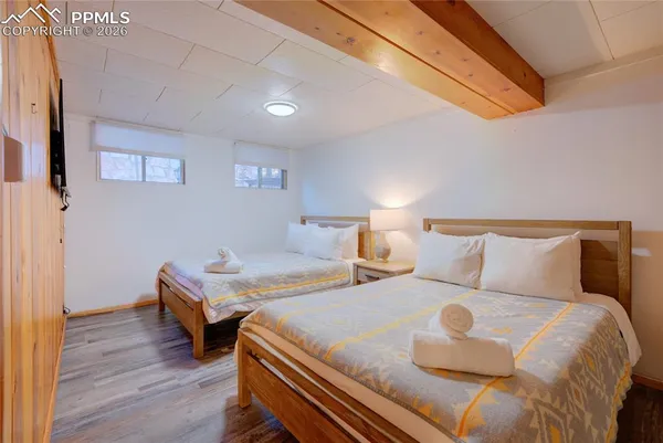 a bedroom with two beds and wooden floor