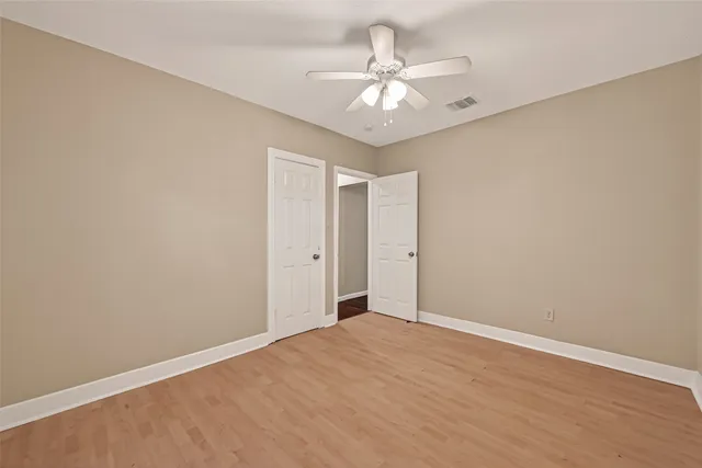 a view of an empty room with a chandelier fan