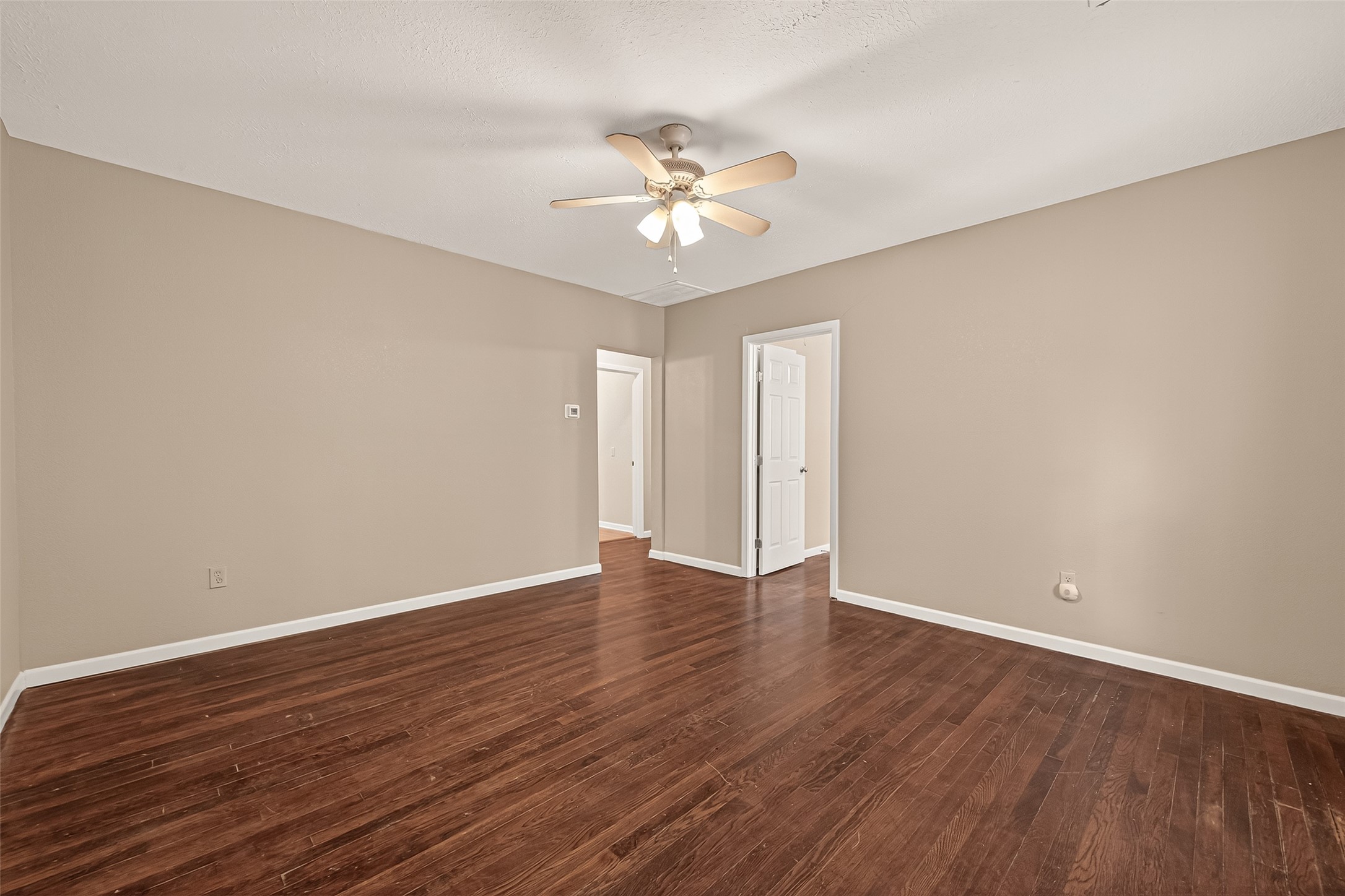 1402 Munger Street Houston, TX 77023 - Photo 2 of 22 a view of an empty room with wooden floor and a ceiling fan