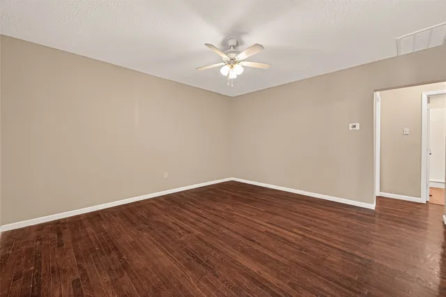 a view of an empty room with wooden floor
