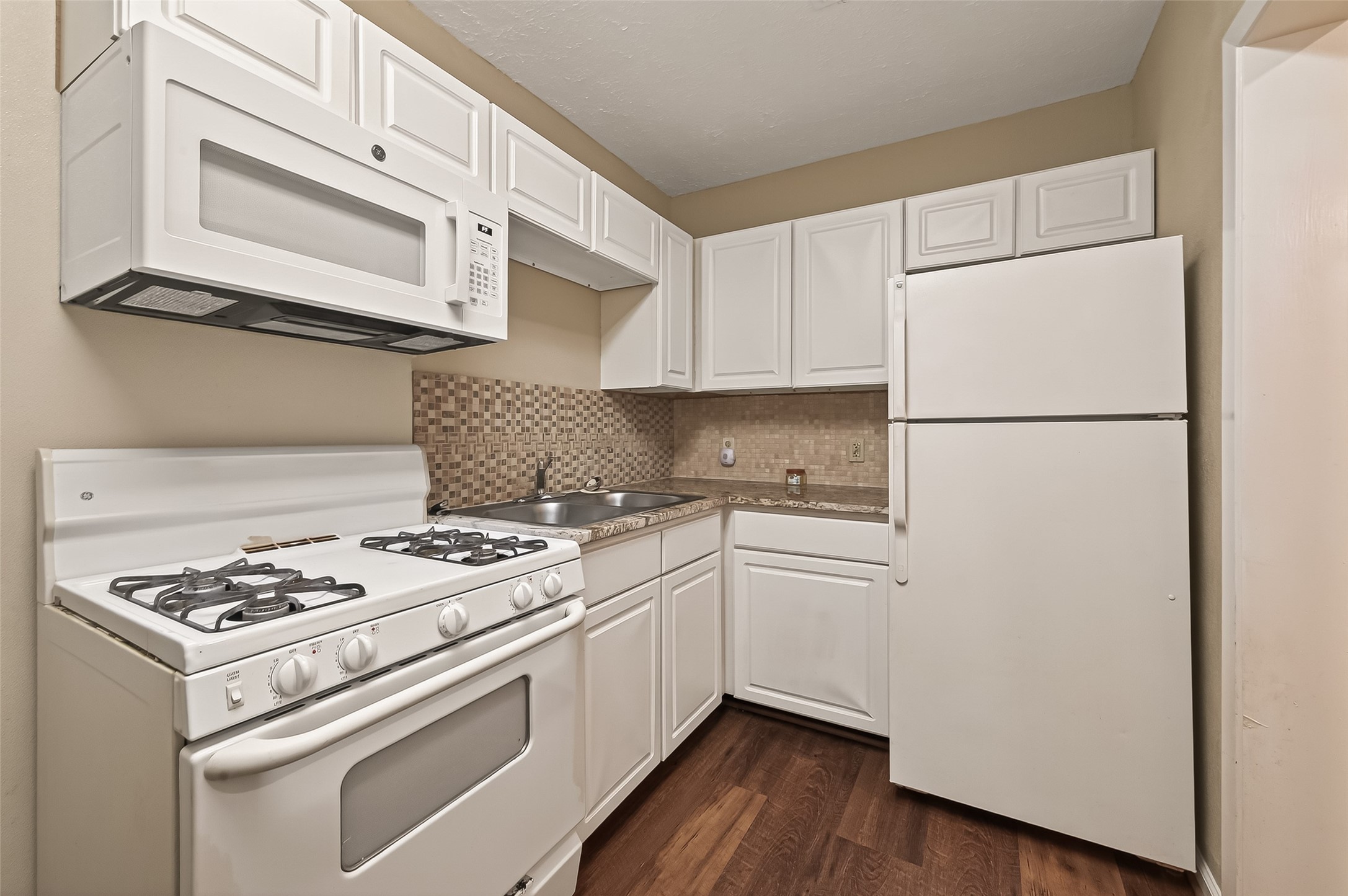 1402 Munger Street Houston, TX 77023 - Photo 6 of 22 a kitchen with a white cabinets and white appliances