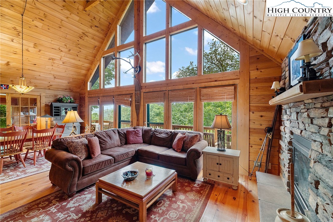 320 Timber Ridge Road Sugar Mountain, NC 28604 - Photo 13 of 30 a living room with furniture a fireplace and a floor to ceiling window