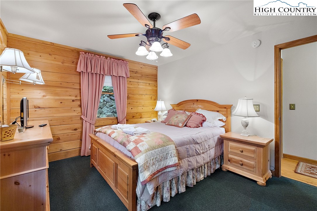 320 Timber Ridge Road Sugar Mountain, NC 28604 - Photo 25 of 30 a bedroom with a bed and a chandelier