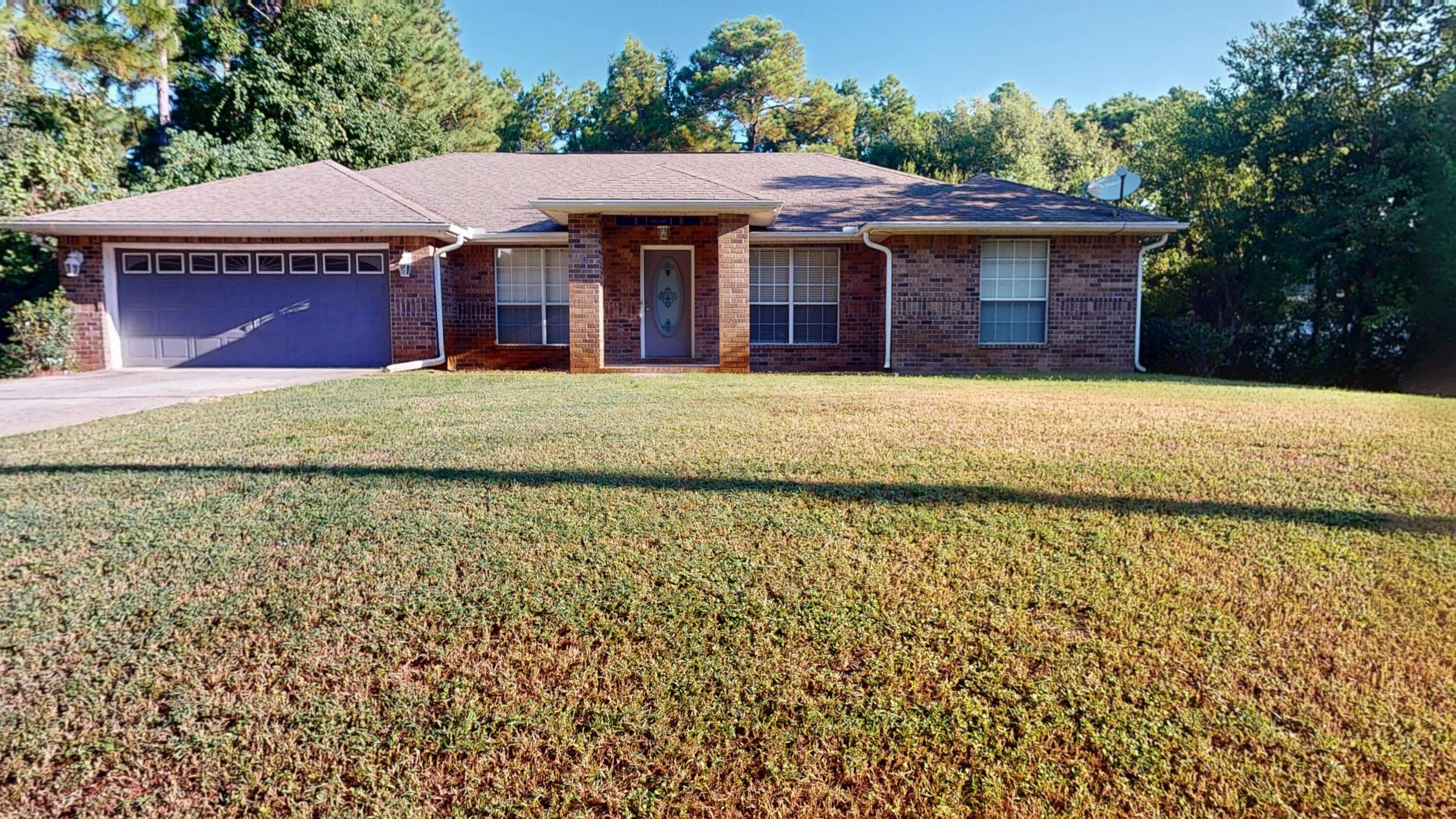 8118 Menorca Street Navarre, FL 32566 - Photo 1 of 14 a front view of a house with a garden