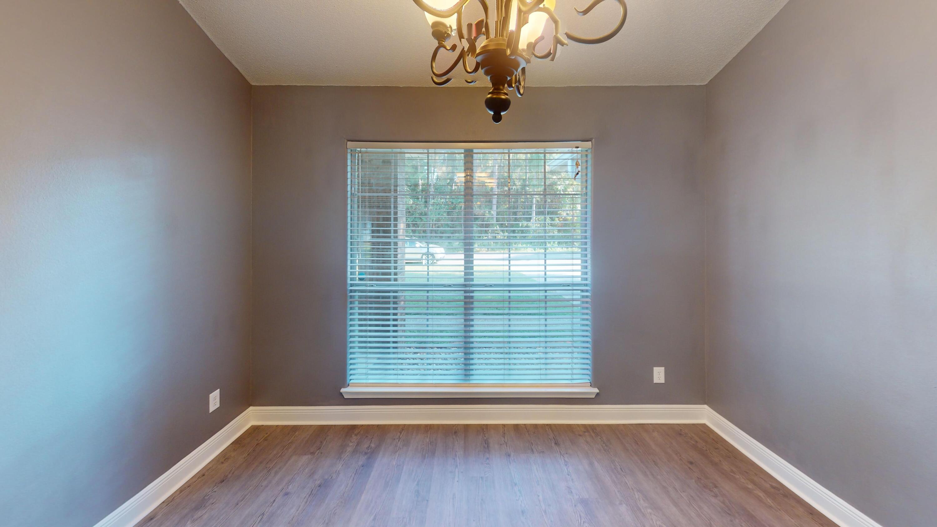 8118 Menorca Street Navarre, FL 32566 - Photo 11 of 14 a view of an empty room with wooden floor and a window
