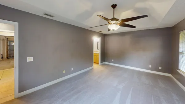 an empty room and chandelier fan