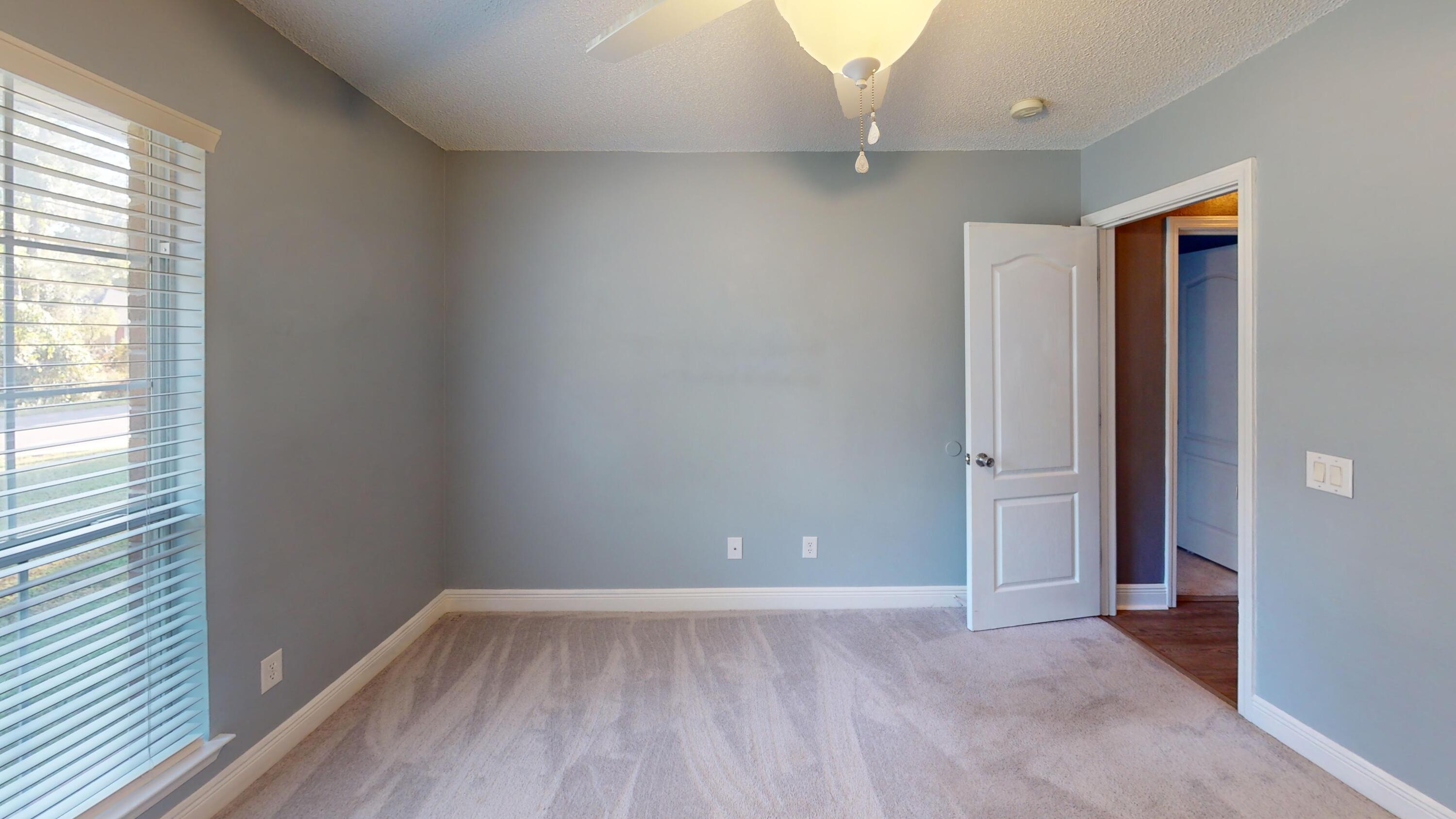 8118 Menorca Street Navarre, FL 32566 - Photo 10 of 14 an empty room with wooden floor and windows