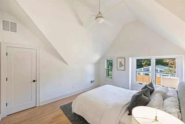 a bedroom with a large bed a couch and a window