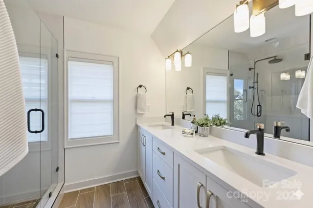 a bathroom with double vanity sinks and a mirror
