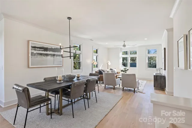 a dining room with furniture a chandelier and wooden floor