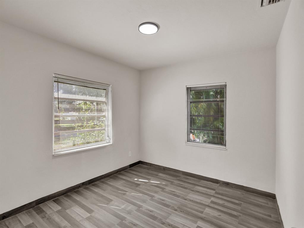 535 Northwest 91st Street, Unit 2 Miami, FL 33150 - Photo 5 of 20 a view of an empty room with wooden floor and a window