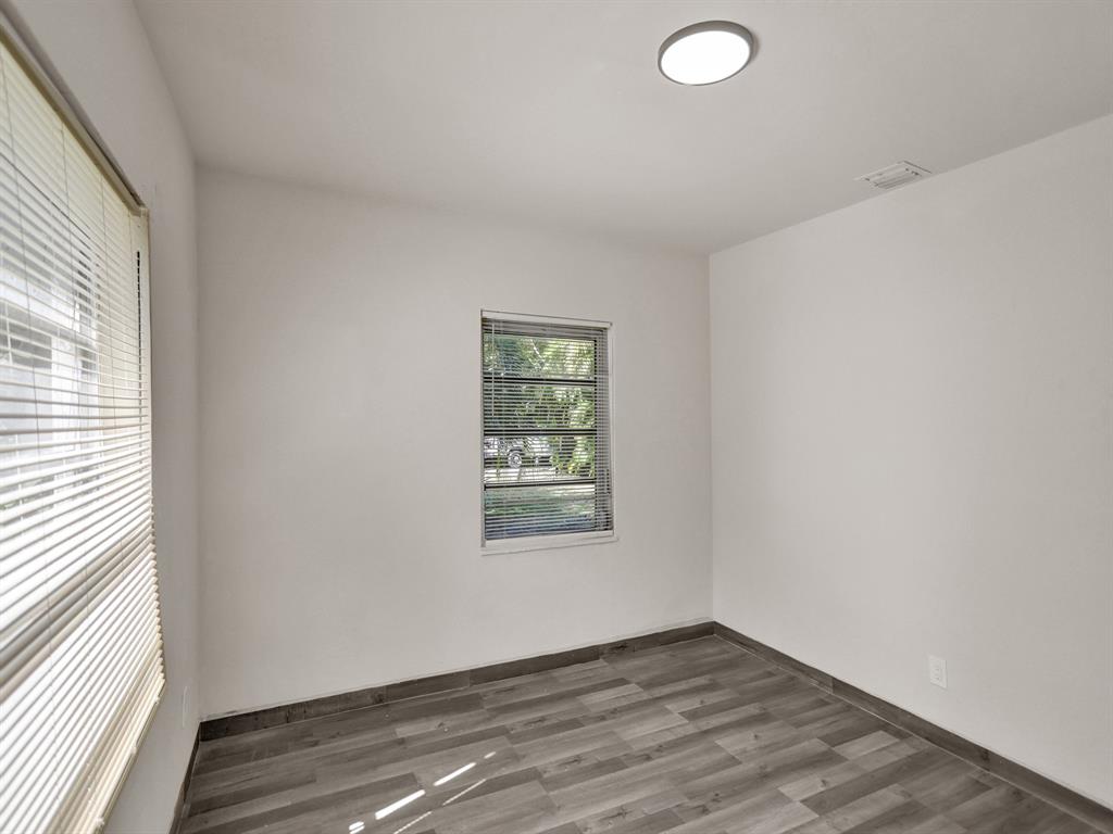 535 Northwest 91st Street, Unit 2 Miami, FL 33150 - Photo 6 of 20 an empty room with wooden floor and windows
