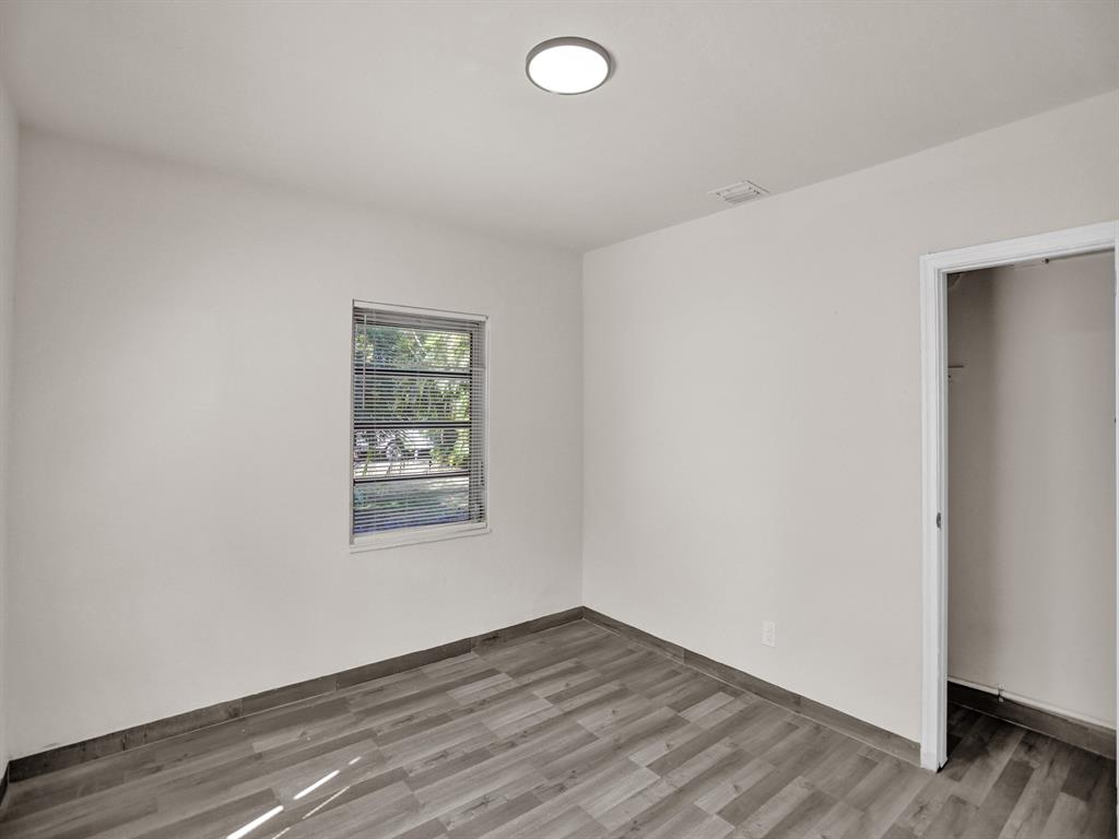 535 Northwest 91st Street, Unit 2 Miami, FL 33150 - Photo 7 of 20 an empty room with wooden floor and windows