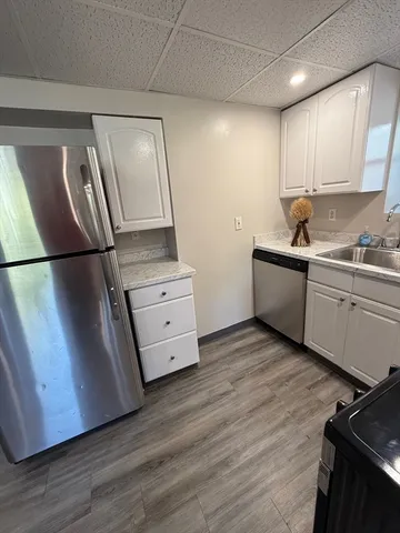 a kitchen with stainless steel appliances a refrigerator sink and wooden floor