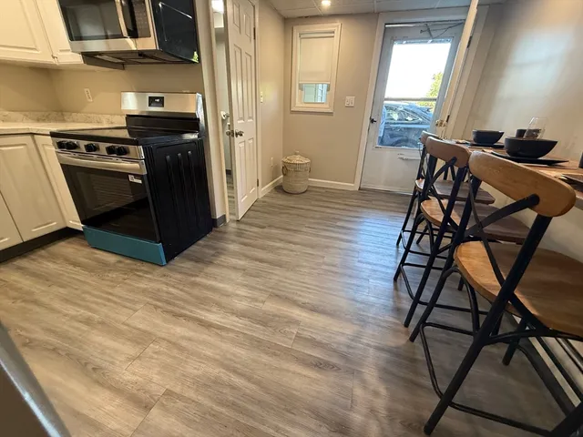 a kitchen with stainless steel appliances wooden floors and wooden cabinets