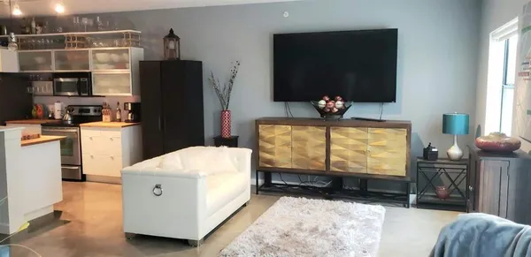 a room with furniture a flat screen tv and a refrigerator