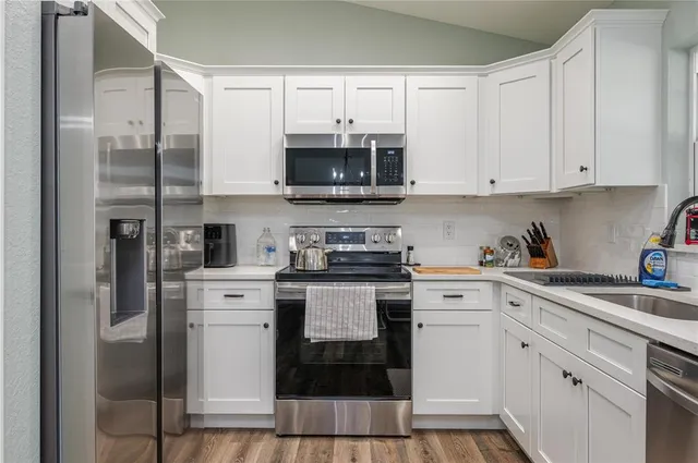 a kitchen with white cabinets and white appliances