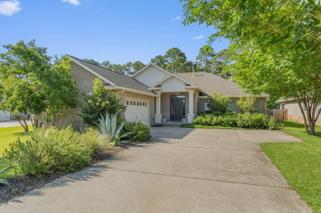 a front view of a house with a yard and potted plants