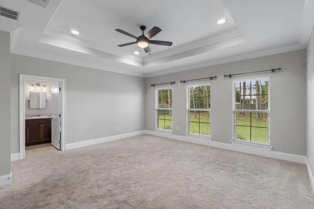 an empty room with window and ceiling fan