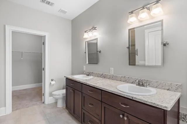 a view of an empty room with wooden floor and a ceiling fan