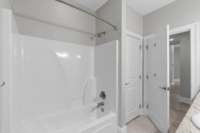 a view of a kitchen with kitchen island granite countertop a table chairs microwave and cabinets