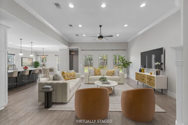 an empty room with wooden floor a ceiling fan a fireplace and windows
