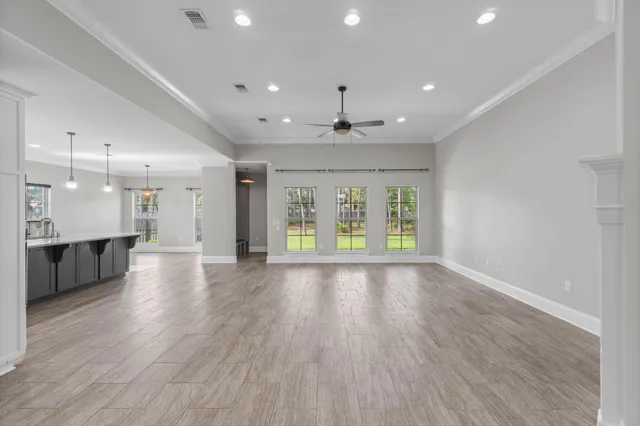 a view of an empty room with a fireplace and a kitchen